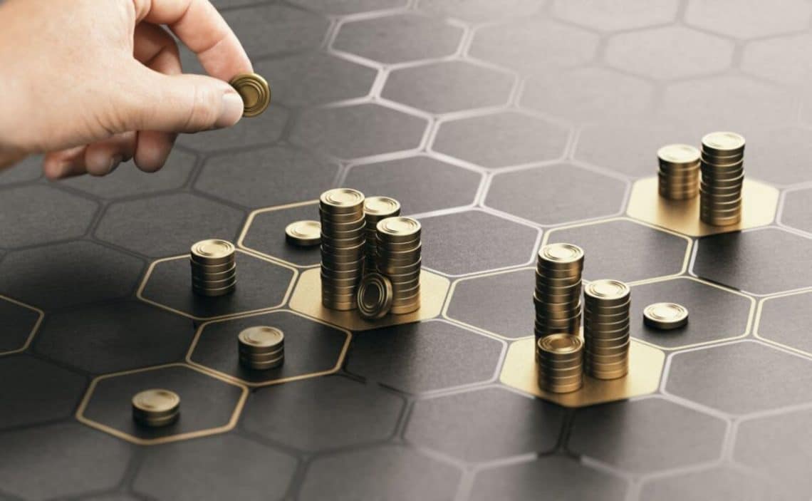 Hand stacking coins over a black background