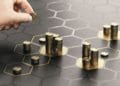 Hand stacking coins over a black background