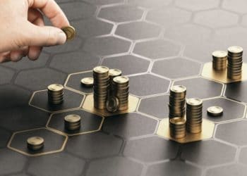 Hand stacking coins over a black background