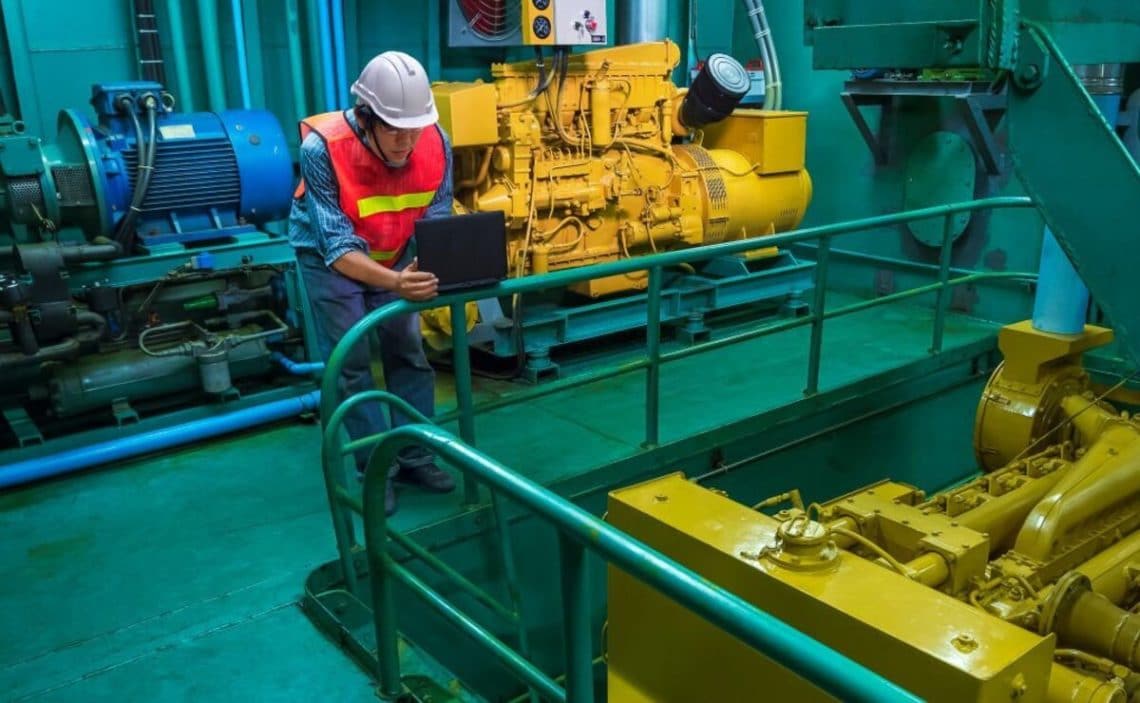 Marine engineer checking engine quality system inside of engine room