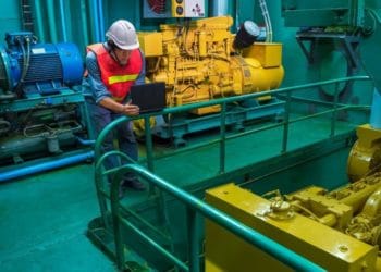 Marine engineer checking engine quality system inside of engine room