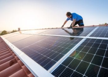 Professional installing a solar panel in a roof