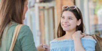 Mother giving credit card with money to daughter
