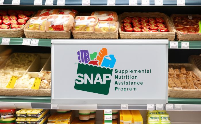 supermarket shelf with foods and products, and a sign with the SNAP Benefits logo