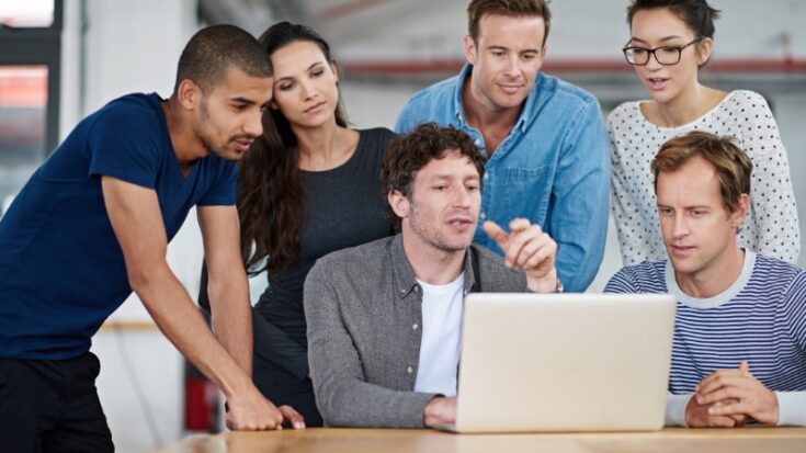 Team reviews work on a laptop as employers assess real skills and readiness beyond academic results
