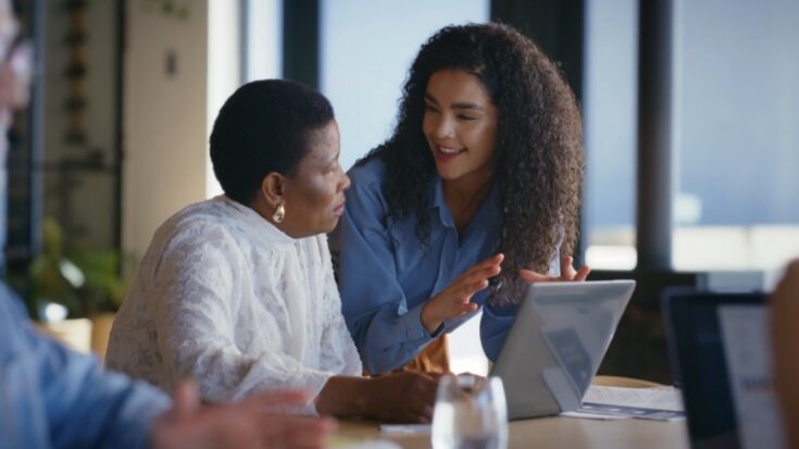 Colleagues review work together on a laptop as employers rely on real experience to assess skills