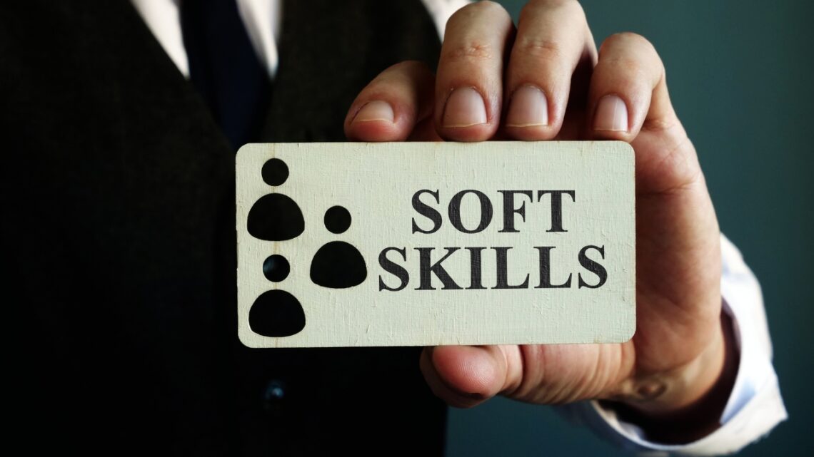 Person in suit holding a card with “soft skills” text