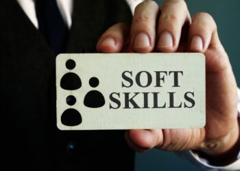 Person in suit holding a card with “soft skills” text