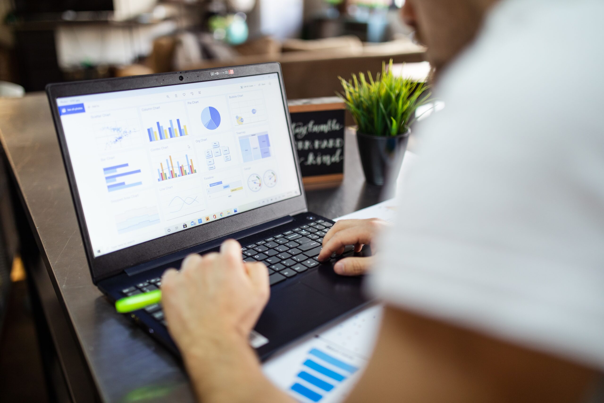 Business analysis charts and graphs displayed on a laptop in a modern office